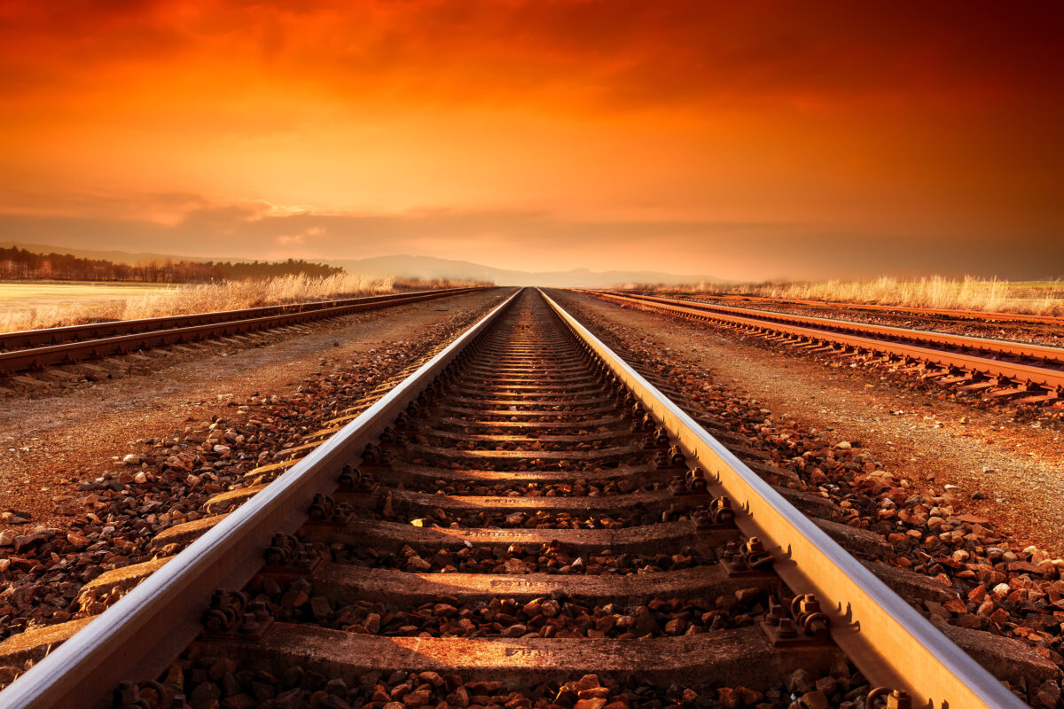 Train tracks goes to horizon in the majestic sunset. Rails-Soleil